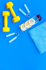 Fitness background with sport equipment for gym and home on blue background top view copyspace