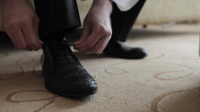 Elegant man tying shoes