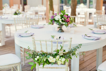 Fototapeta na wymiar chairs with flowers and eucalyptus