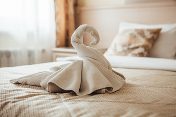 Fototapeta na wymiar Swan figurine made from towels on a bed in a hotel room.