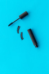 decorative cosmetic set with mascara on blue woman desk background top view mock up