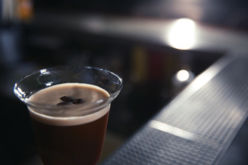 Glass of martini espresso cocktail in bar, closeup. Space for text