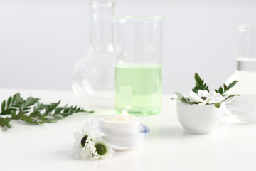Skin care product, ingredients and laboratory glassware on table. Dermatology research
