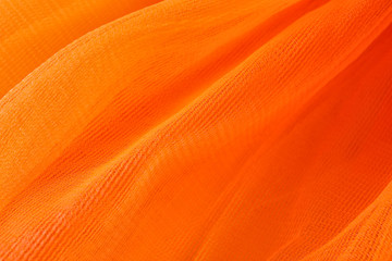 Texture of orange tulle as background, closeup