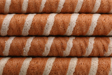 Tasty wafer roll sticks as background, top view. Crispy food