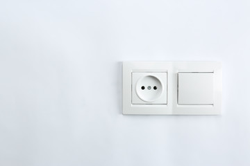 Light switch and power socket on white background. Electrician's equipment