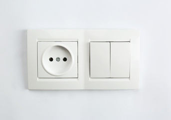 Light switch and power socket on white background. Electrician's equipment