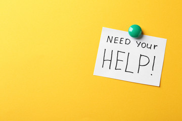 Paper note with words NEED YOUR HELP on color background. Space for text