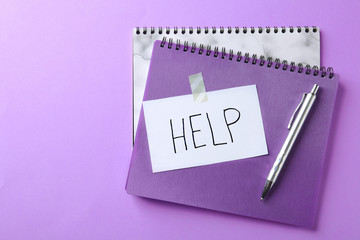 Flat lay composition with stationery, note HELP and space for text on color background