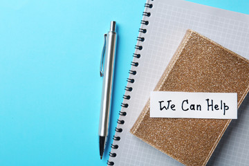 Flat lay composition with stationery, note WE CAN HELP and space for text on color background