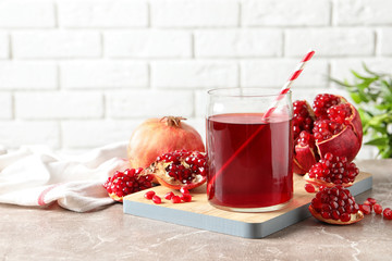 Composition with glass of fresh pomegranate juice on table. Space for text