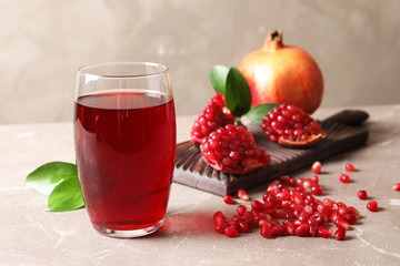 Composition with glass of fresh pomegranate juice on table