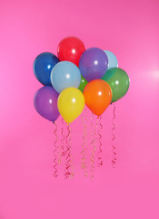 Many bright balloons floating on color background