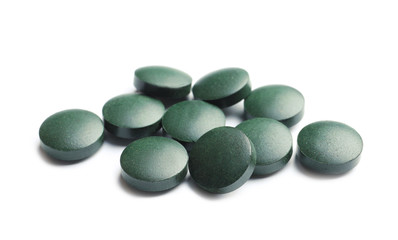Spirulina tablets on white background. Healthy lifestyle