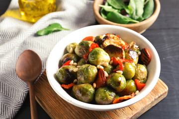 Bowl of warm salad with Brussels sprouts and carrots on table