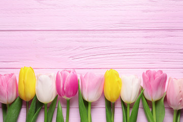 Flat lay composition of beautiful spring tulips on wooden background, space for text. International Women's Day