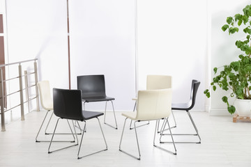 Empty chairs prepared for group psychotherapy session indoors