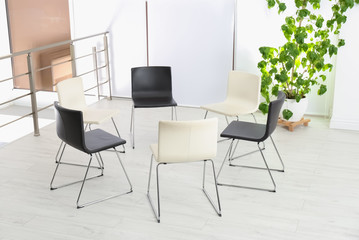 Empty chairs prepared for group psychotherapy session indoors