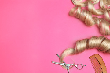Flat lay composition with hair locks and tools on color background. Space for text
