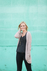 beautiful young model posing in front of teal wall