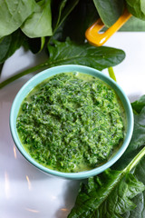 Healthy vegetarian or vegan food, cooked green spinach with cream, ingredient for many dishes like pasta, ravioli or soup