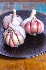 Three bulbs of fresh violet French garlic close up