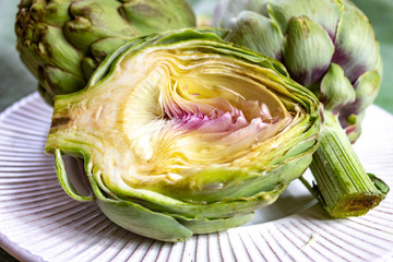 Obraz premium Heads of fresh uncooked artichoke flowers close up