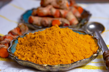 Fresh turmeric or curcuma root and dried powder, wildly used in Asia and India as spice, food ingredient and for medicinal purposes.