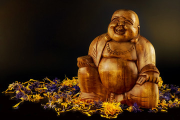 wooden buddha statue decorated with flowers