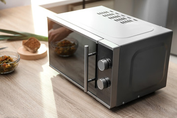 Modern microwave oven on table in kitchen