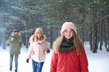 Teenage girl with family in snowy winter forest