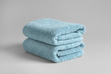 Stack of fresh fluffy towels on grey background