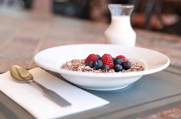 close up breakfast granola with berries and milk