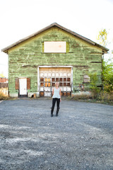 female model standing in front of old green building