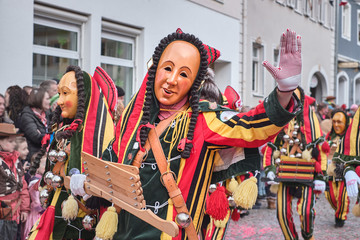 Colorful carnival figure with wooden ratchet. Street Carnival in Southern Germany - Black Forest.