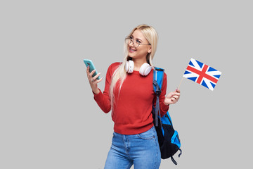 Online Education, foreign language translator, english, student - smiling blond woman in headphones holding mobile phone and British flag. Distance learning