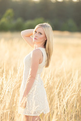 beautiful young lady looking over shoulder in field