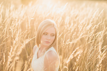 Beautiful girl sitting in sunny field