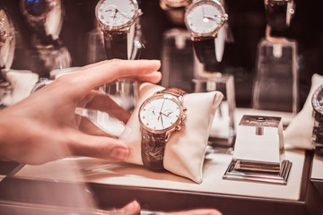 Close-up of the seller's hand shows the exclusive men's watch from the new collection in the luxury...