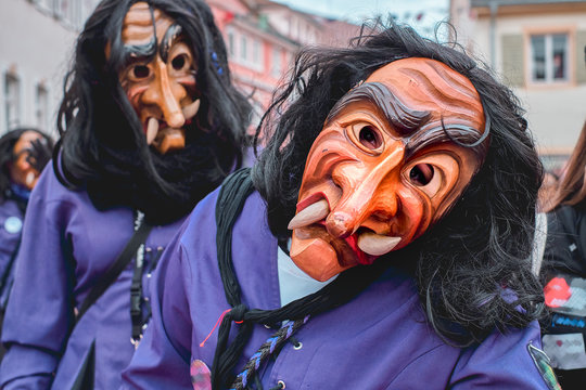 Funny carnival figure in violet costume looks into the camera. Street Carnival in Southern Germany - Black Forest.