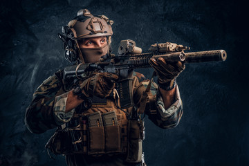Elite unit, special forces soldier in camouflage uniform holding an assault rifle with a laser...