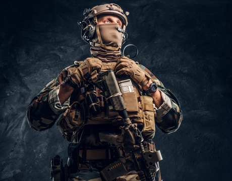 Elite unit, special forces soldier in camouflage uniform. Studio photo against a dark textured wall