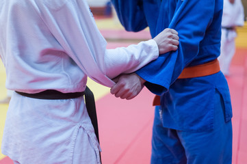 Two judokas holding each other sleeve in tight grip