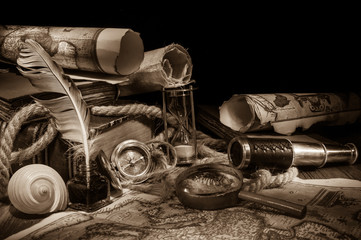 Old maps and vintage objects on a wooden table, sepia effect