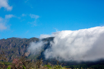 Passatwolken wälzen sich über die Berge der Cumbre Vieja