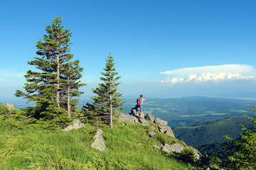 Fototapeta na wymiar Young man in the mountain Panoramic view Summertime Selective focus