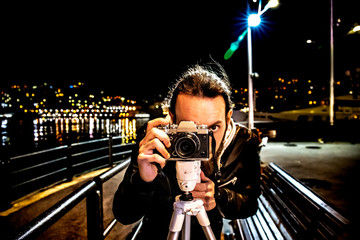 young man taking a photo in night, near sea. 