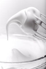 Whipped egg whites for cream on wooden table, top view