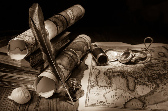 Old maps and vintage objects on a wooden table, sepia effect