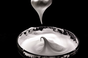 Whipped egg whites for cream on wooden table, top view
